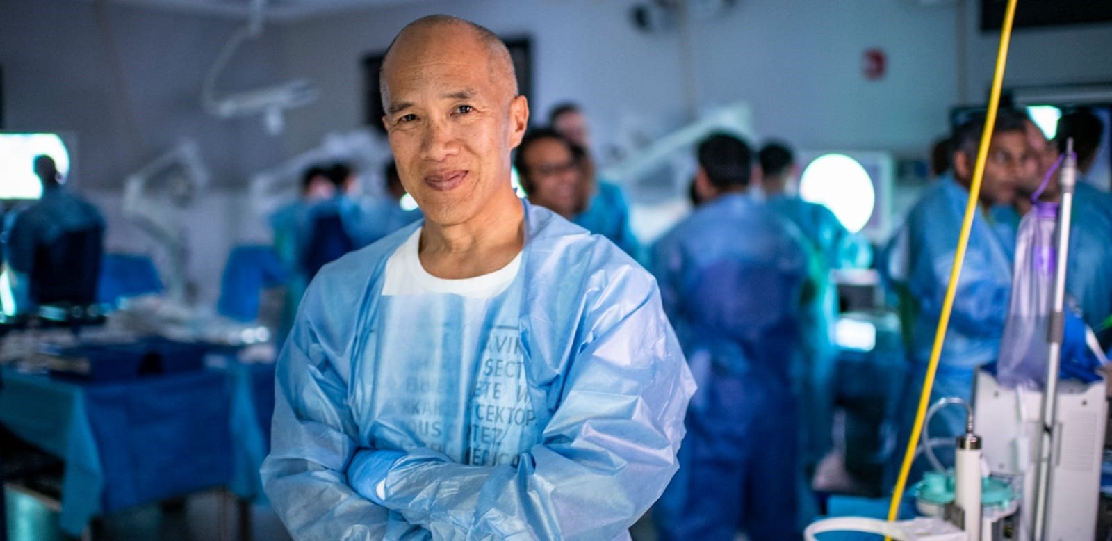 Dr Charlie Teo AM, neurosurgeon and founder of the Charlie Teo Foundation, in a surgical training lab with surgeons behind him